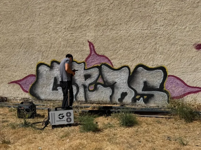 Operario de Garbinavar con el equipo láser eliminando un grafiti de un muro